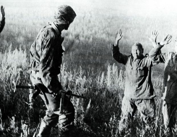 Suboficial de la Waffen SS junto a unos prisioneros soviéticos