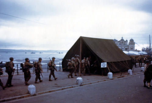 Soldados Americanos marchando a través de la ciudad costera de Weymouth, Inglaterra, en ruta al abordaje de los buques de desembarco preparados para la invasión de Francia, hacia finales de mayo y principios de junio 1944