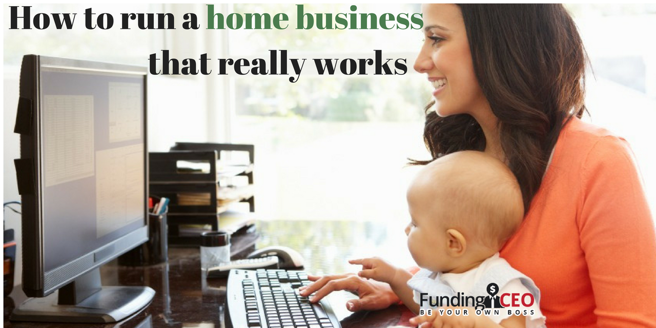 Work at home mom, sitting at her desk, giggling with her baby and working on the computer with a stack of books and pens.